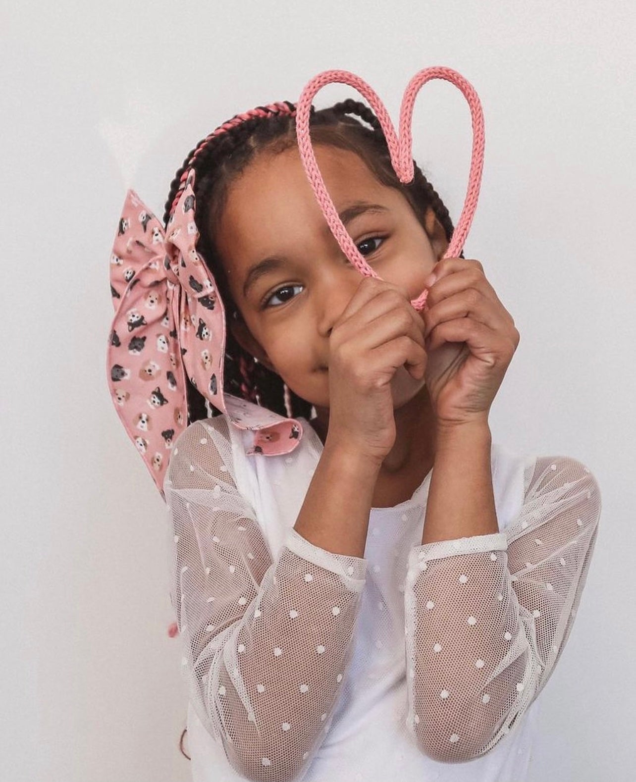 Little girl holding wire heart shape.