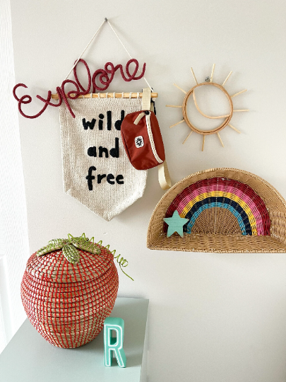 Knitted wire word "explore". It's hung in a child's bedroom with lots of nature and adventure inspired items.
