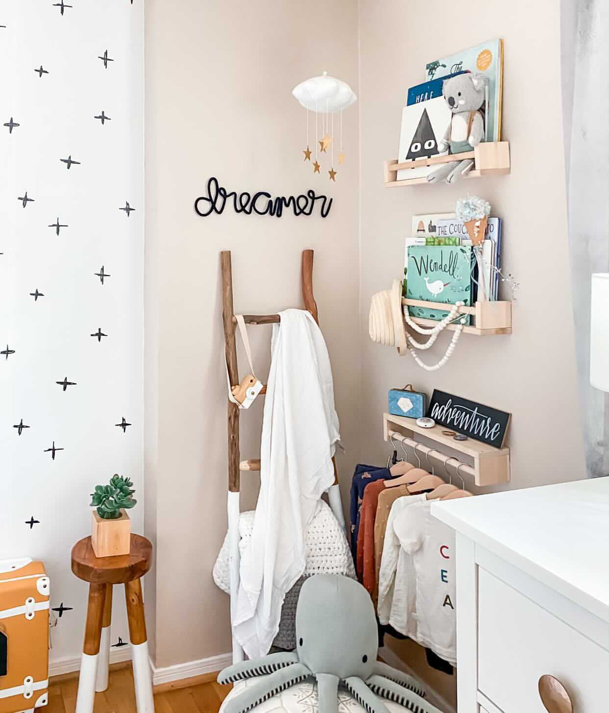 Knitted wire word "dreamer" in black. It's styled in a child's bedroom corner with some bookshelves.