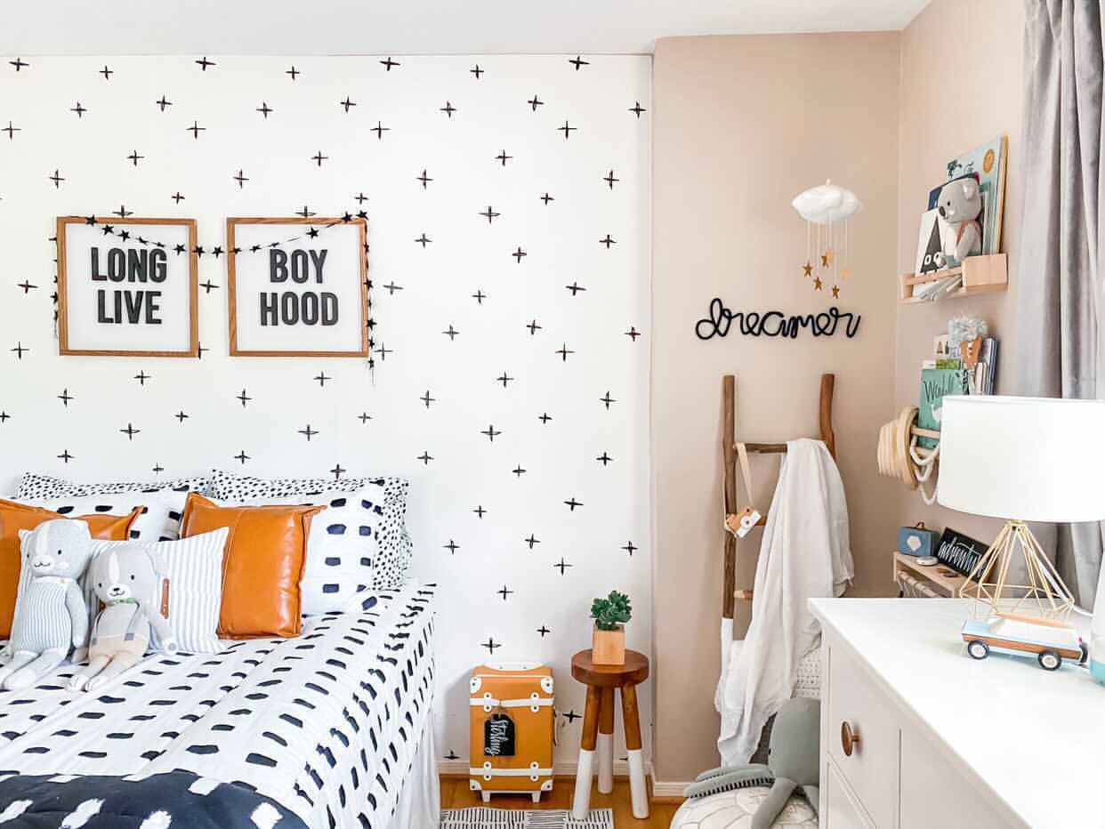 Knitted wire word "dreamer" in black. It's styled in a child's bedroom corner with some bookshelves. The style of the room is scandinavian inspired with lots of black and white, graphic patterns and natural wood tones.