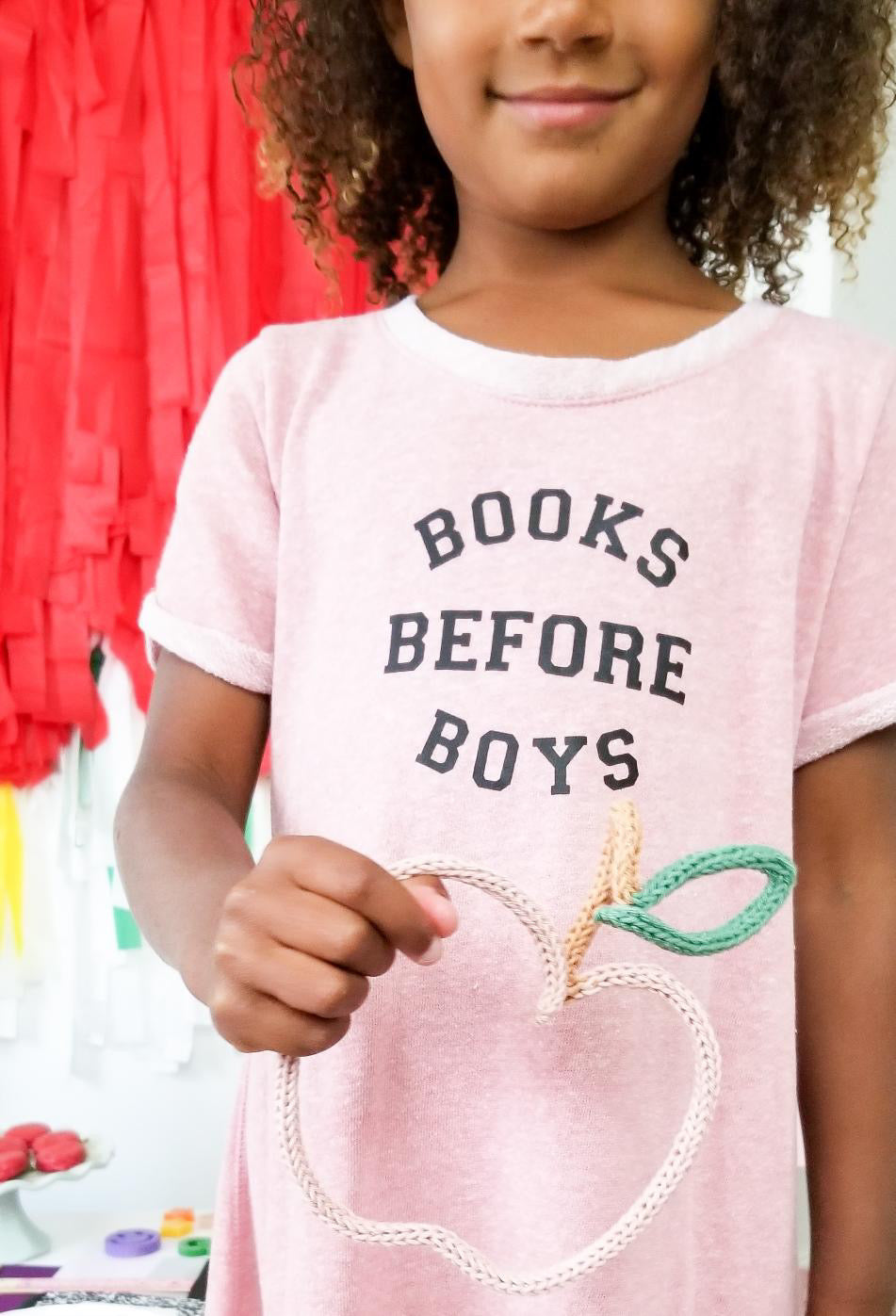 Little girl holding apple wire shape.