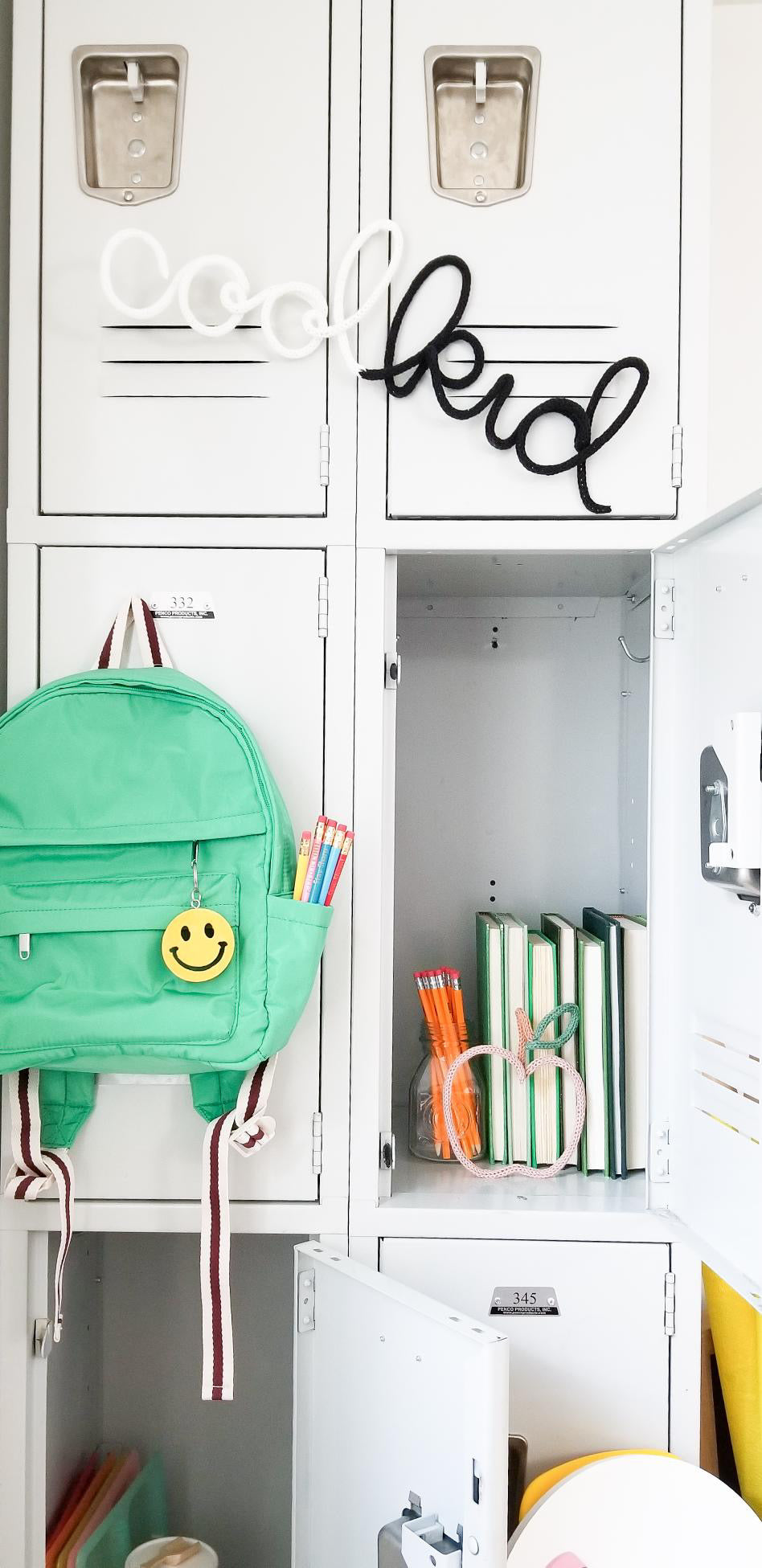 Picture of kid's lockers with apple wire shape placed inside with books and other school supplies. 