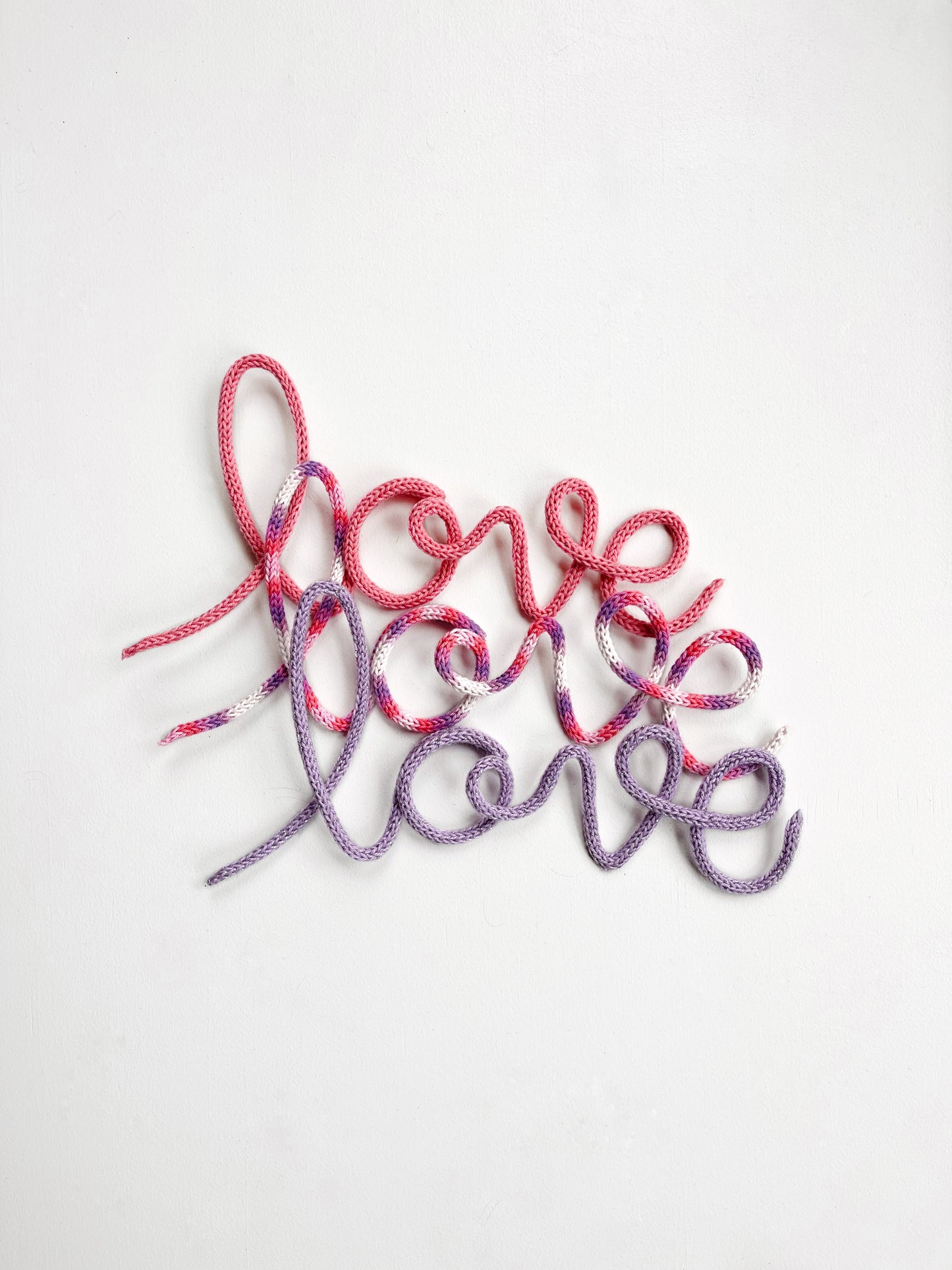 Knitted wire word "love" in various colors.