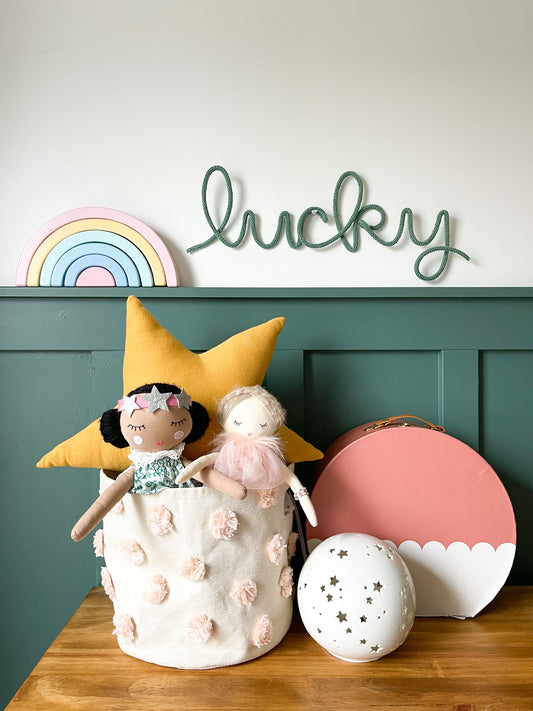 Knitted wire word lucky. It's displayed in a child's room over their desk. 