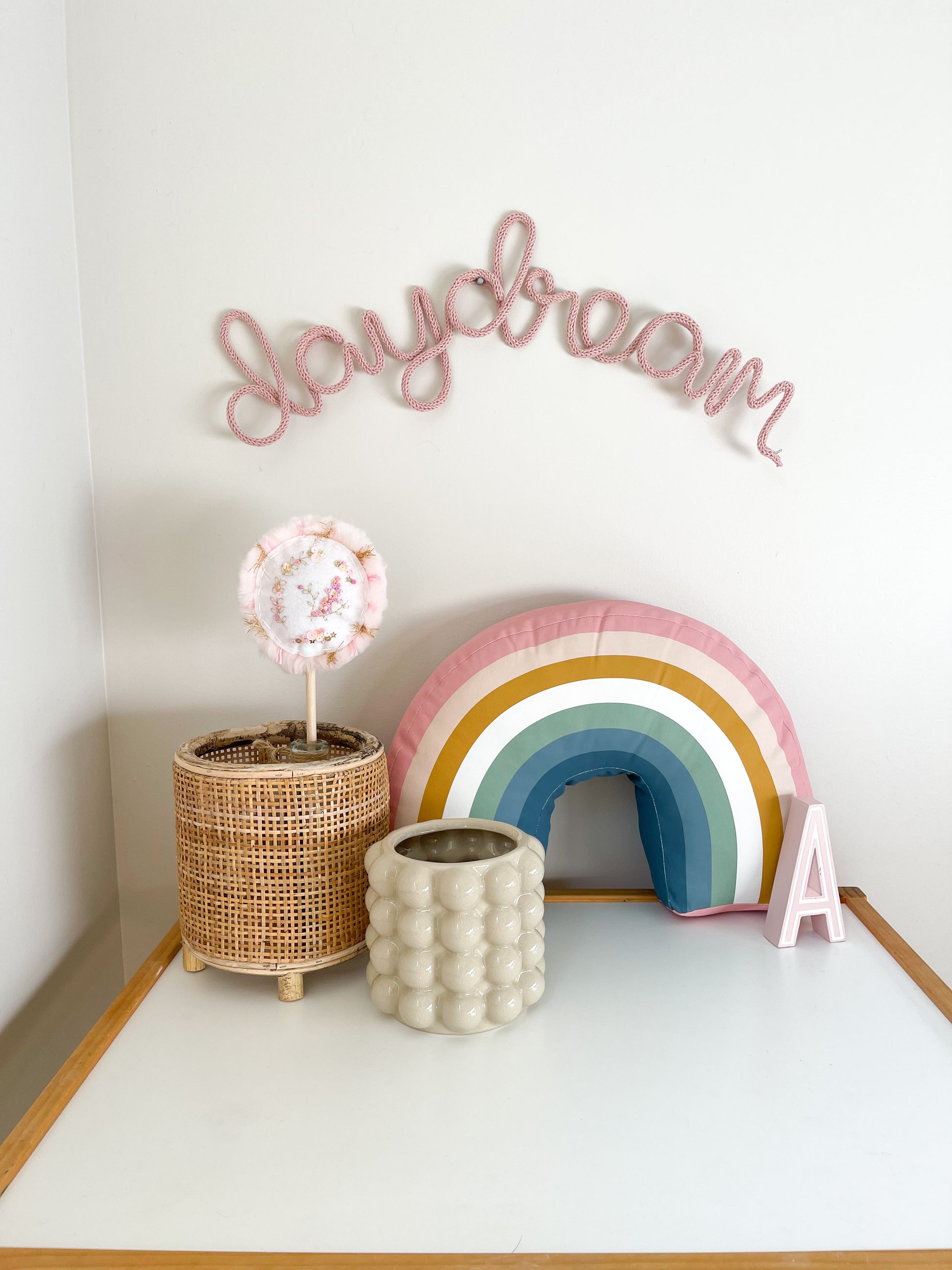 Knitted wire word sign daydream. It's hung above a child's desk in a girl's room.