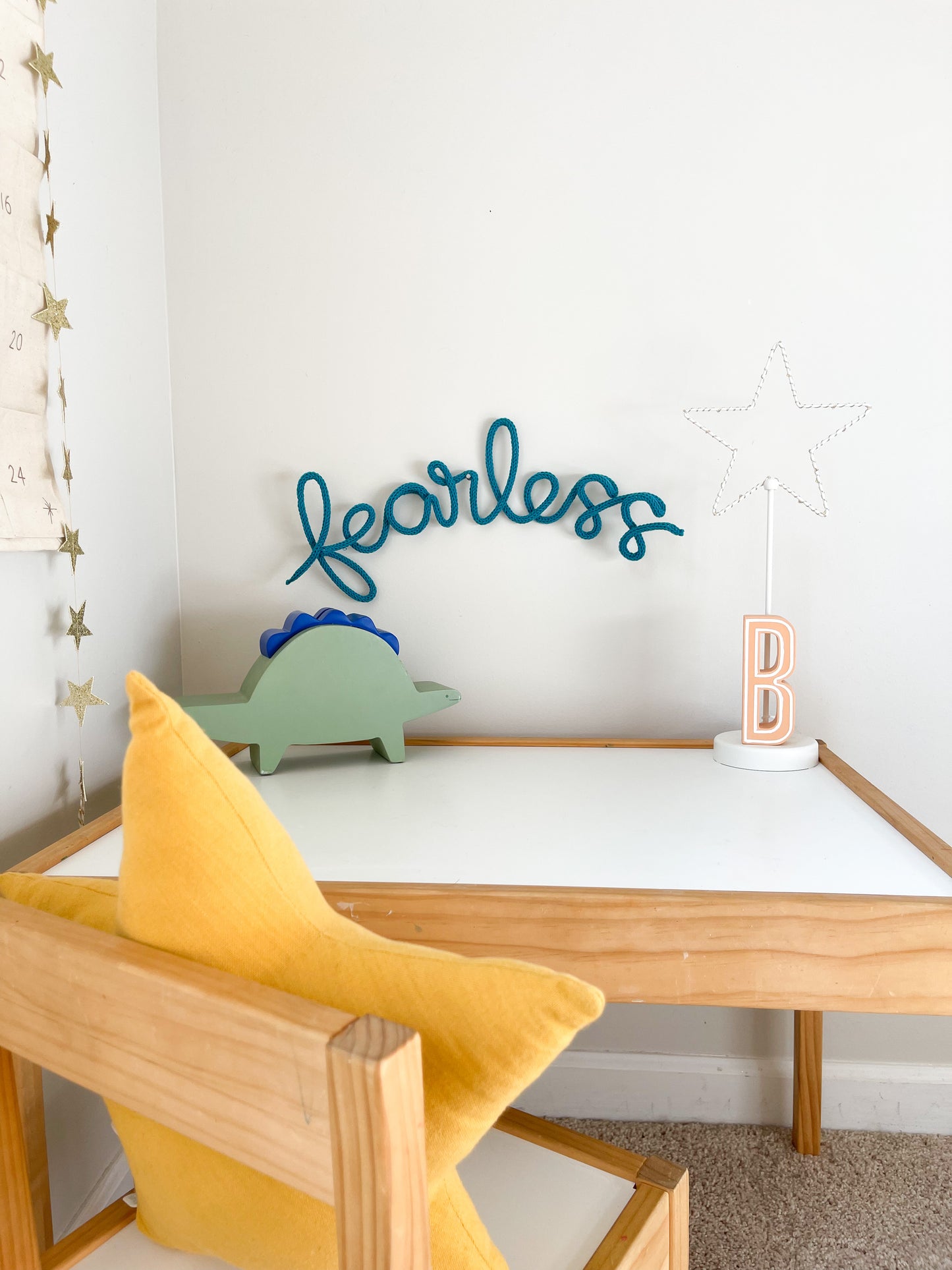 Knitted wire word "fearless". Hung above child's desk. 