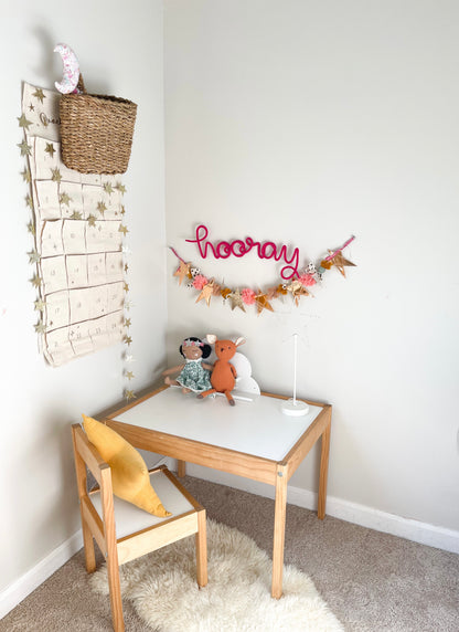 Knitted wire word art. "hooray" sign is hung above a desk in a child's bedroom. 