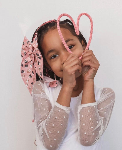 Little girl holding wire heart shape.