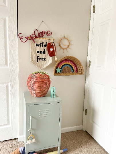 Knitted wire word "explore". It's hung in a child's bedroom with lots of nature and adventure inspired items.